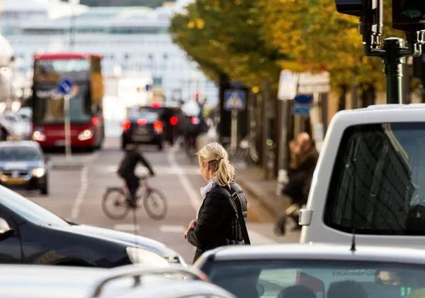 Gata med fotgängare, cyklist, bil och buss. Foto.