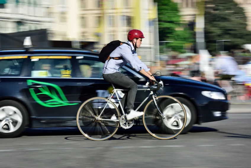 Cyklist och bil i trafiken. Foto